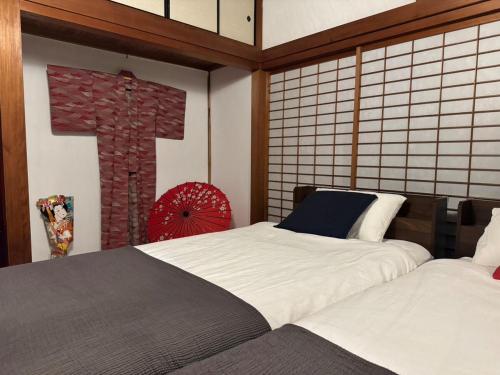 a bedroom with two beds and a cross on the wall at 釜炒り茶の宿陽だまりTraditional Japanese house near Kumano Kodo and Nachi Falls with parking bikes garden and onsite tea house in Nachikatsuura