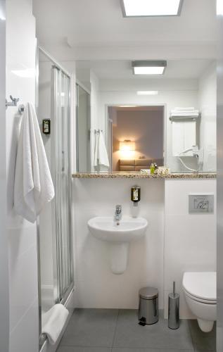 ein weißes Badezimmer mit Waschbecken und Toilette in der Unterkunft Hotel Petropol in Płock