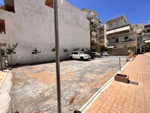 a parking lot with cars parked in front of a building at IRA - ΗΡΑ Hotel in Kalamata