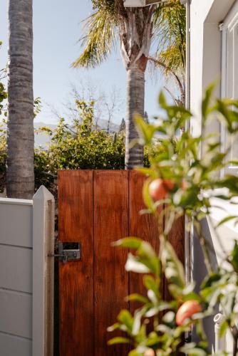 a wooden gate in front of a house with a palm tree at Goedehoop Boutique Apartment in Robertson