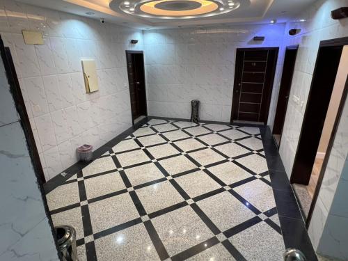 a bathroom with a tile floor and a room with doors at الشاطئ الذهبي in Jeddah