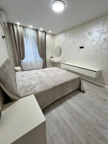 a bedroom with a large bed and a window at TOTO ApartHotel in Chişinău