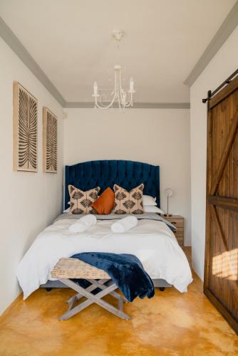 a bedroom with a large bed with a blue headboard at Goedehoop Boutique Apartment in Robertson