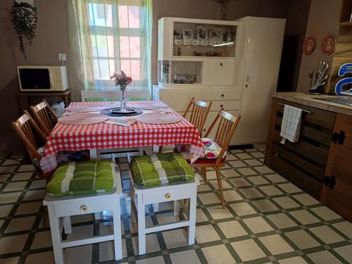 a kitchen with a table with a red and white table cloth at Pony Cottage Farmhouse and Minifarm in Hosszúvölgy