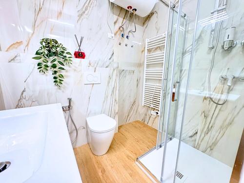 a bathroom with a glass shower and a toilet at Maestrale - Elegant Apartment in Udine