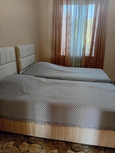 two twin beds in a bedroom with a window at Gigi's Guest House in K'obulet'i