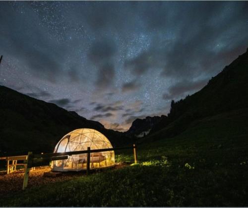 Un invernadero en un campo bajo un cielo nocturno en Bubble Suite St Antoenien, en Luzein
