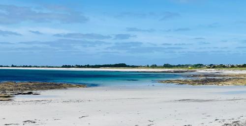 a beach with the blue water and sand at Maison typique du pays bigouden in Tréffiagat