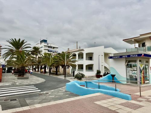 eine Straße mit Gebäuden und Palmen in einer Stadt in der Unterkunft The Cozy Coast in Piles