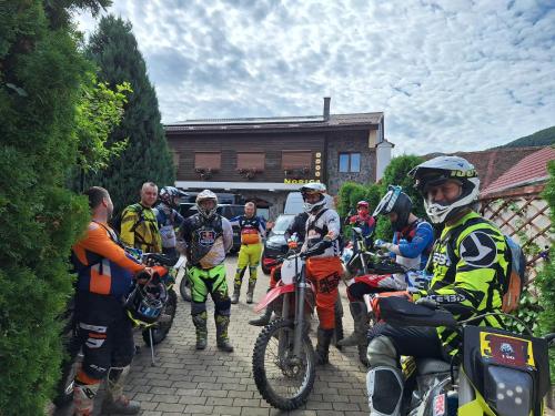 a group of people are standing around on motorcycles at Norica Guesthouse in Gura Rîului
