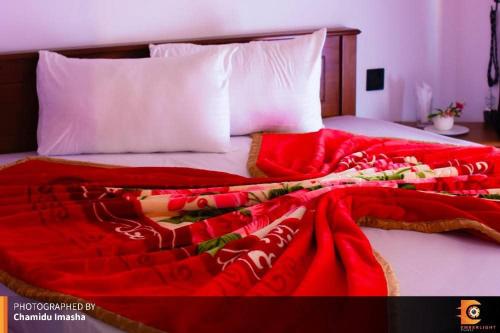 a red blanket on top of a bed at Sithgiri Drem line cottage in Nuwara Eliya