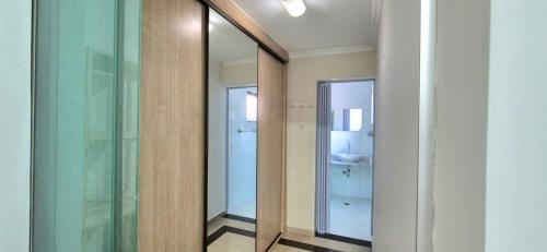a hallway with a mirror and a bathroom with a sink at House 8 in Sao Paulo