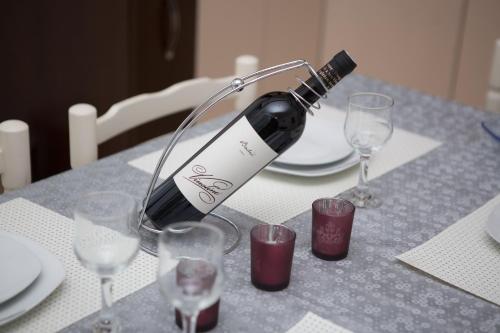 a bottle of wine sitting on a table with glasses at Villa Jelena in Trebinje