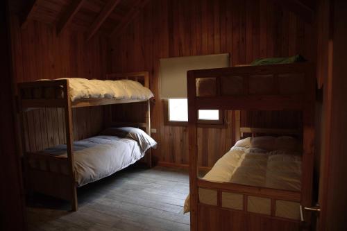 a room with two bunk beds and a window at Casa en Lago Hermoso sobre Laguna Cristalina con Muelle Privado in San Martín de los Andes