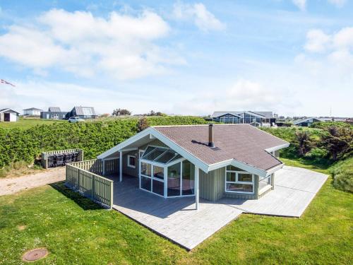 a small house with a roof on a lawn at 8 person holiday home in Hjørring-By Traum in Lønstrup