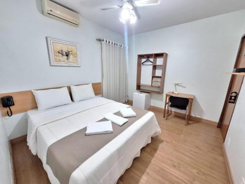 a bedroom with a large bed with two towels on it at Hotel Itapema in Valinhos