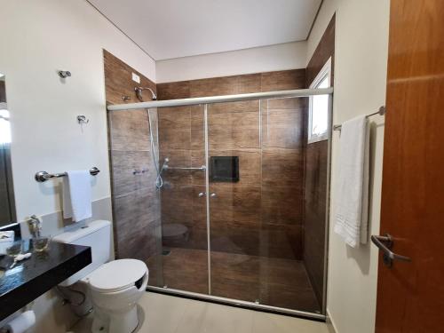 a bathroom with a glass shower with a toilet at Hotel Itapema in Valinhos