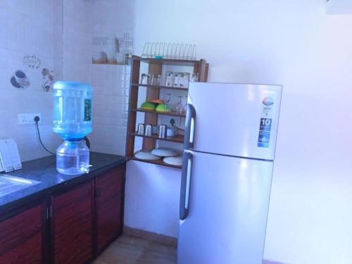 a kitchen with a white refrigerator and a blender at Shalom Deluxe Luxury Apartments and Villa in Colva