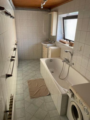 a white bathroom with a tub and a sink at Casa Domingo - Oase im Herzen des Waldviertels in Schwarzenau