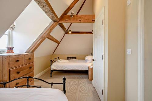 a bedroom with two beds in a attic at Thymblethorpe - Blythview in Blyford