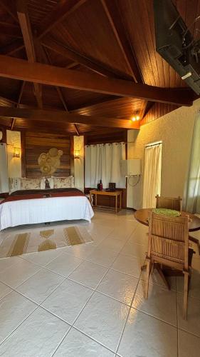 a large room with a bed and a table at Pousada Vitorino in Angra dos Reis