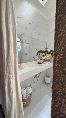 a white bathroom with a sink and a mirror at Pousada Vitorino in Angra dos Reis
