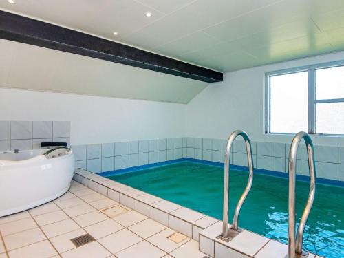 a large bathroom with a tub and a bath tub at 5 star holiday home in Juelsminde in Sønderby