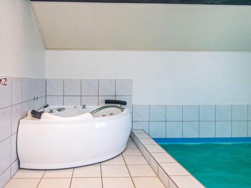 a bath tub in a bathroom with a pool of water at 5 star holiday home in Juelsminde in Sønderby