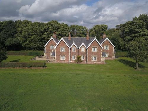 a large brick house in a field with trees at Sure Studio Doncaster in Doncaster