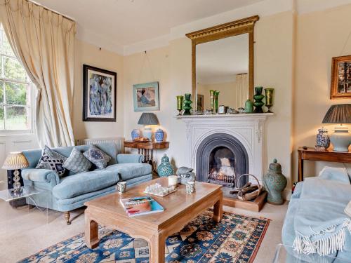 a living room with a blue couch and a fireplace at 5 Bed in Fitzhead 95570 in Fitzhead