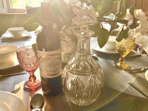 a table with a bottle of wine and a glass vase at 5 Bed in Fitzhead 95570 in Fitzhead