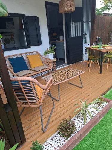a patio with a rattan chair and a table and a table at Ti Caz la Zac in Saint-Louis