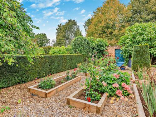 a garden with three raised beds of flowers at 5 Bed in Fitzhead 95570 in Fitzhead