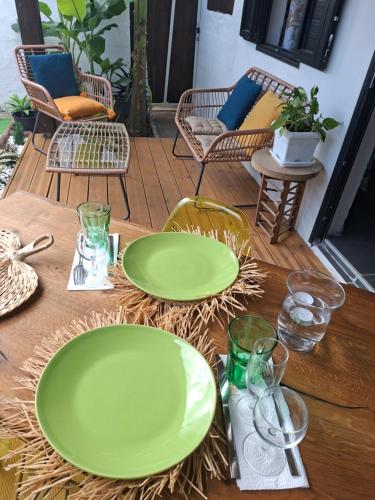 two green plates on a wooden table with chairs at Ti Caz la Zac in Saint-Louis
