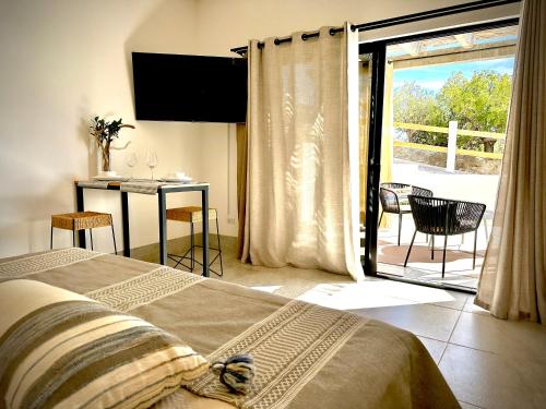 a bedroom with a bed and a balcony with a table at Casa del Mar - Luxury Seaside Villa in Boca de la Vinorama