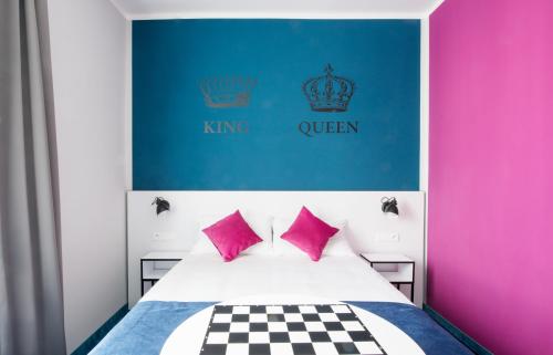 a bedroom with a bed with pink and blue at Ibis Styles Gniezno Stare Miasto in Gniezno