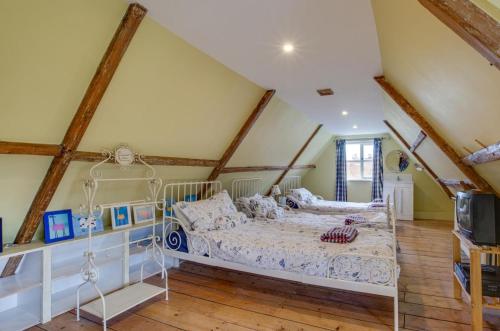 een slaapkamer met een wit bed op zolder bij Dressmakers Cottage in Wrentham