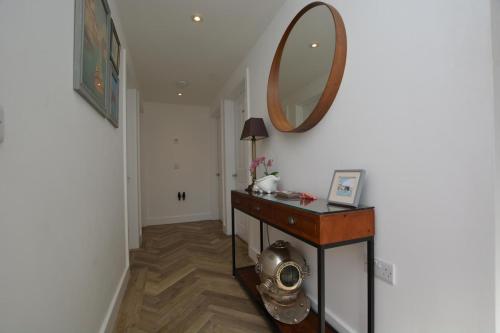 a hallway with a table and a mirror on the wall at Valley View in Mevagissey