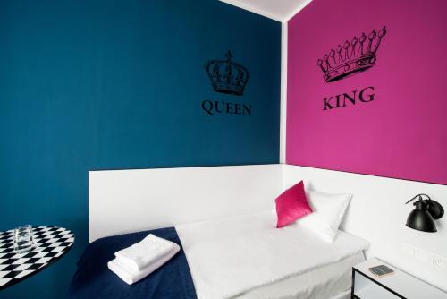 a room with a bed with pink and blue walls at Ibis Styles Gniezno Stare Miasto in Gniezno