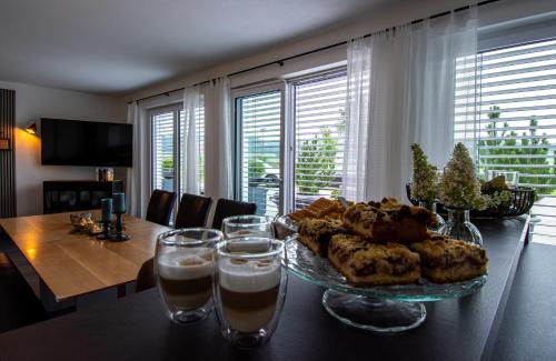 a table with a plate of food and glasses of water at Ferienwohnung Felicitas in Aichstetten