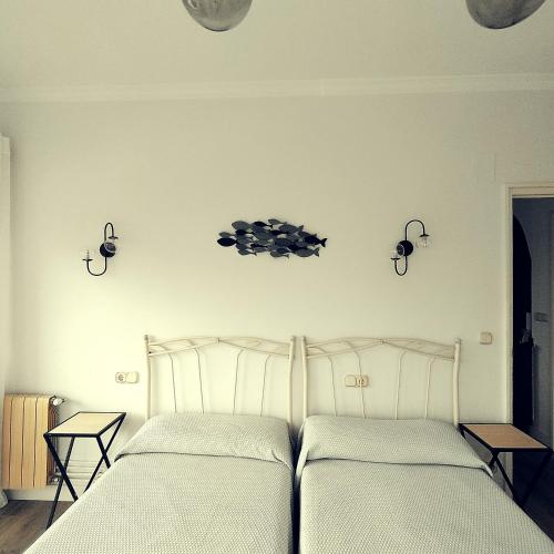 a bedroom with two beds and lights on the wall at Primera línea in Castro-Urdiales