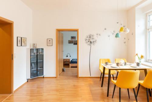 a dining room with a table and yellow chairs at Am Kanonenberg in Quedlinburg
