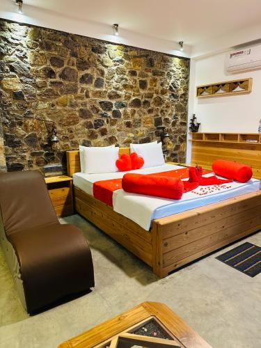 a bedroom with a bed with red pillows and a chair at The Symbol of Ella in Ella