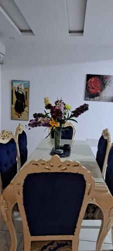 a dining room table with a vase of flowers on it at Balcony of Carthage in Bin Rhilouf