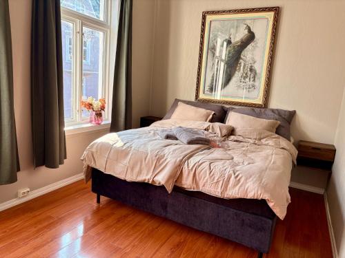 a bed in a bedroom with a picture on the wall at Charming apartment Nygårdsparken in Bergen