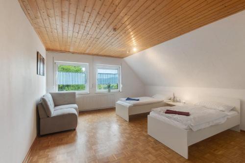 a bedroom with a bed and a couch and a chair at Ferienhaus Talblick Sellinghausen in Schmallenberg