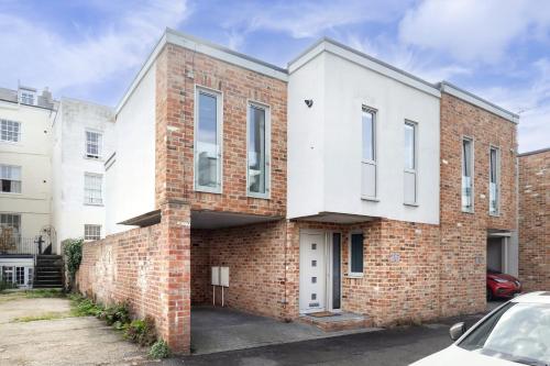 a brick house with a white facade at Contemporary 2-Bed 2-Bath Home with Parking in Cheltenham