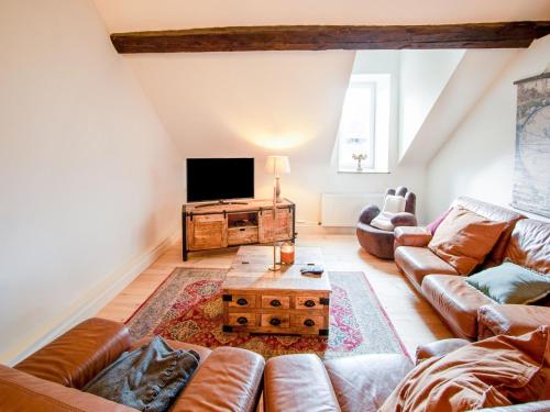 a living room with a couch and a tv at Castle with wellness and zipline in Gesves