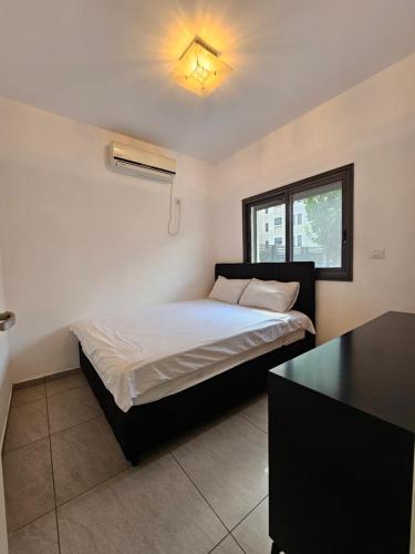 a bedroom with a bed and a desk in it at Luxury Duplex • 3BR • Garden + Balcony • Parking in Nahariyya