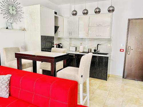 salon z czerwoną kanapą i kuchnią w obiekcie Beachfront Saranda w Sarandzie